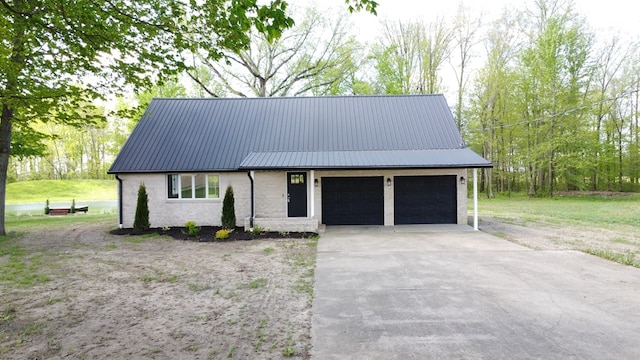 5616 Windfall Rd, Galion, OH 44833 - view of front facade with metal roof, a garage, brick siding, and concrete driveway