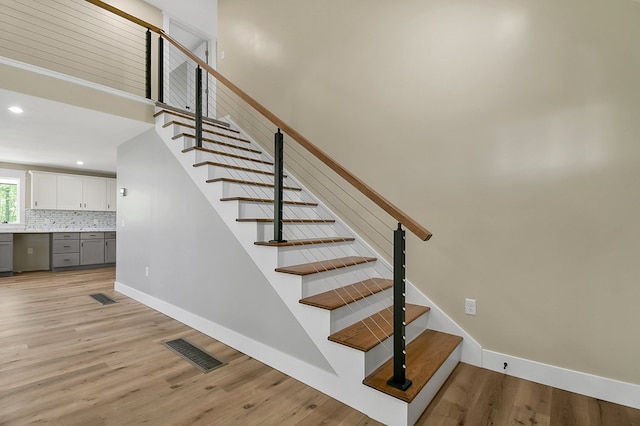 5616 Windfall Rd, Galion, OH 44833 - staircase featuring wood finished floors, recessed lighting, baseboards, and a towering ceiling