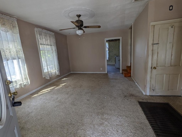 carpeted spare room with ceiling fan