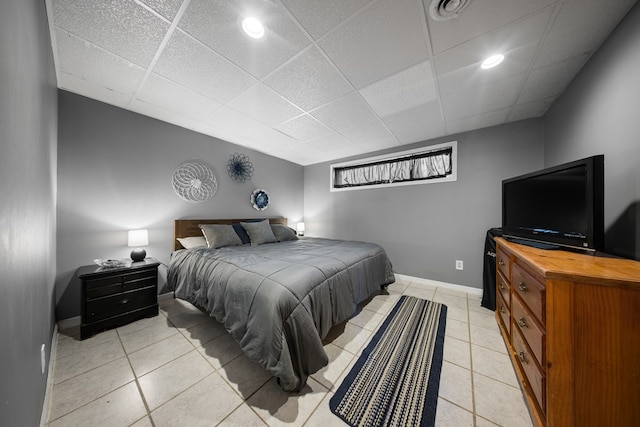 bedroom with a drop ceiling and light tile patterned floors