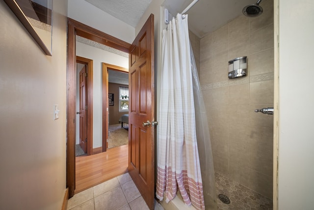 bathroom with curtained shower and tile patterned floors