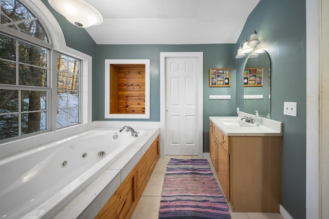 bathroom with tile patterned flooring, a bathtub, vanity, and vaulted ceiling