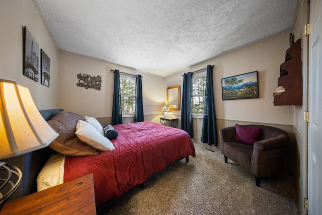 carpeted bedroom with crown molding, wood walls, and a textured ceiling