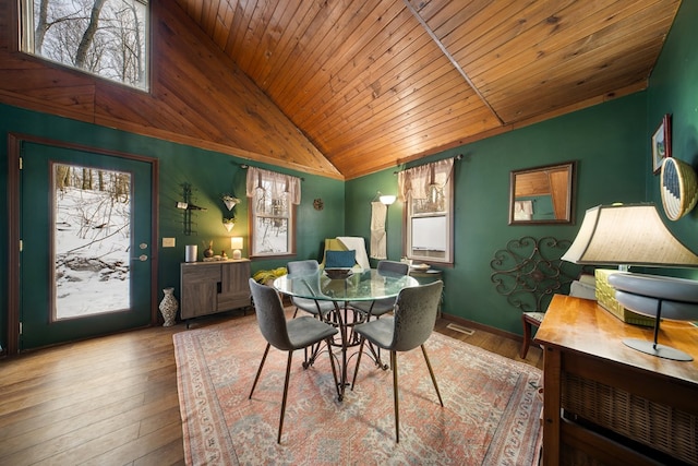 dining area with high vaulted ceiling, wooden ceiling, and light hardwood / wood-style flooring