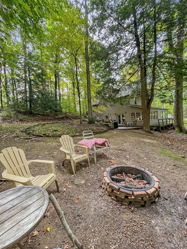 view of yard featuring a deck and an outdoor fire pit