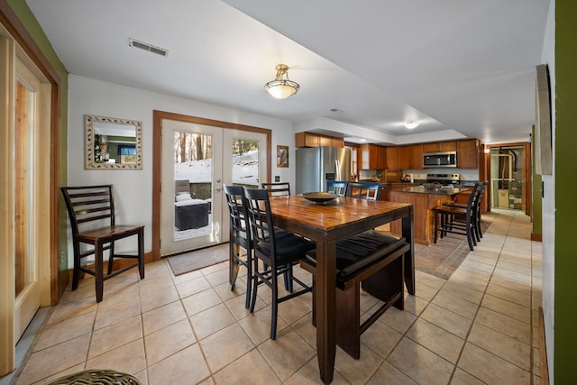 tiled dining room featuring french doors