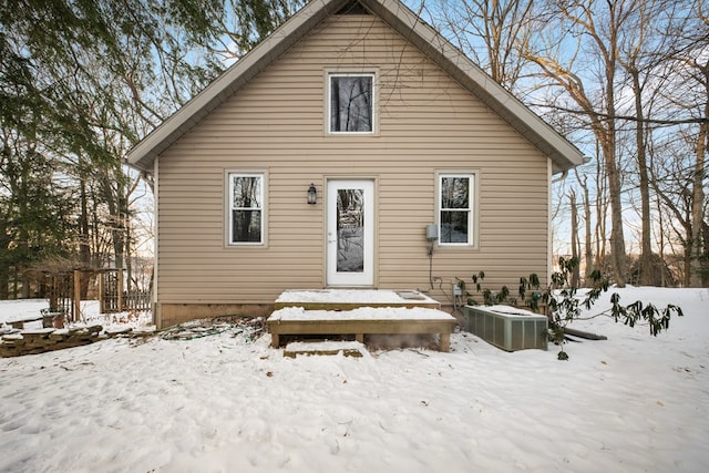 snow covered house featuring central AC unit