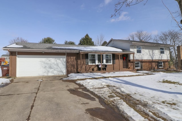 tri-level home featuring a garage and covered porch