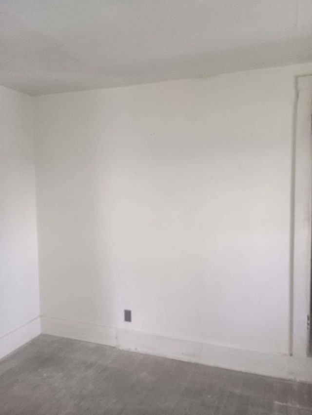 unfurnished room with concrete flooring