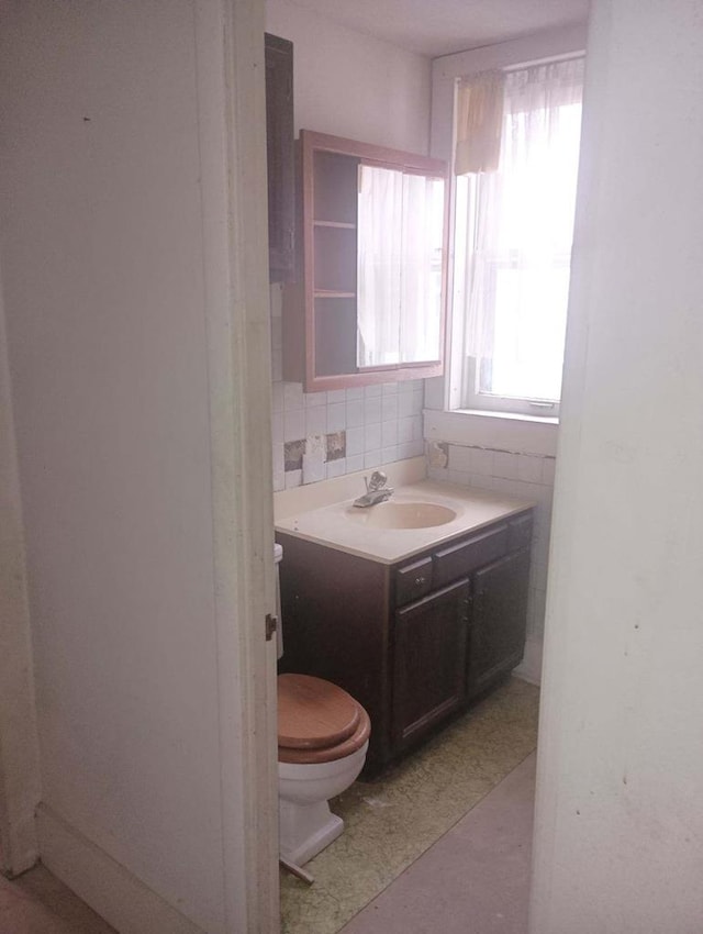 bathroom featuring vanity, tasteful backsplash, toilet, and tile walls