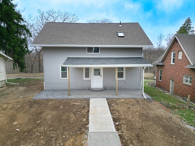 rear view of property featuring roof with shingles