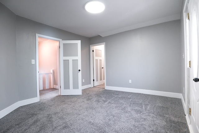 unfurnished bedroom with carpet flooring and baseboards