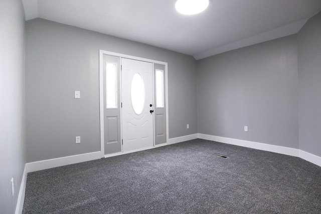 foyer with baseboards, visible vents, and dark carpet