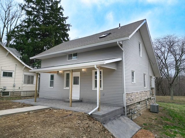 view of front of house with covered porch, central AC unit, and a shingled roof