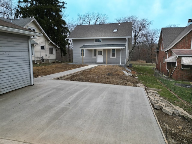 rear view of house featuring covered porch and fence