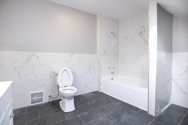 full bathroom featuring tile walls, a wainscoted wall, visible vents, toilet, and a tub