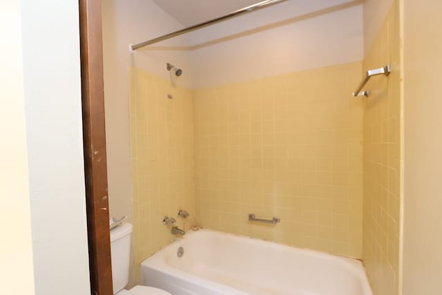 bathroom featuring tiled shower / bath and toilet