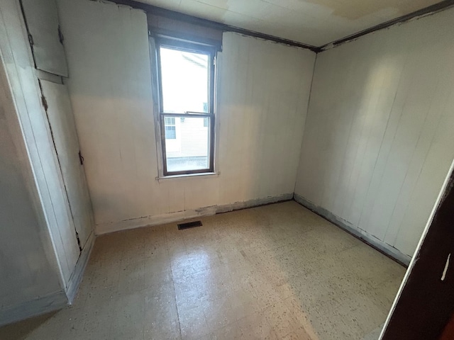 spare room with tile patterned floors, visible vents, and a wealth of natural light