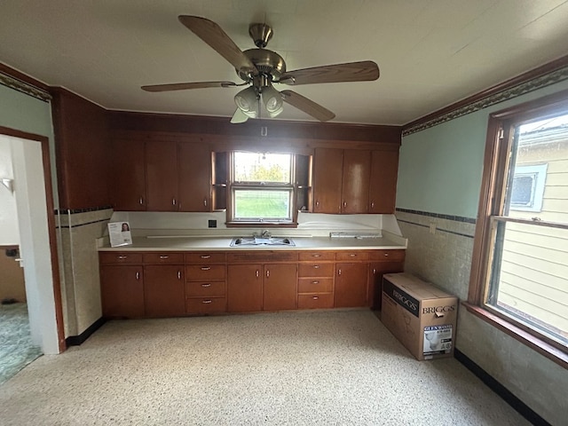 kitchen featuring a sink, a ceiling fan, a healthy amount of sunlight, and light countertops