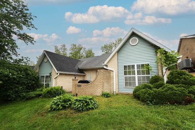 1690 Riva Ridge Dr, Mansfield, OH 44904 - view of front of house featuring brick siding, a front yard, a shingled roof, and cooling unit