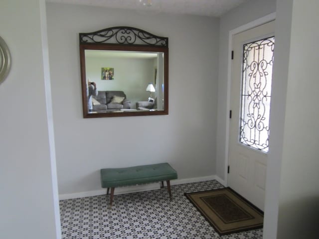 entrance foyer with baseboards and tile patterned floors