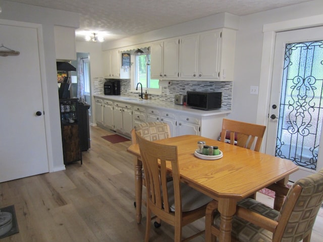 dining area featuring light wood finished floors and a textured ceiling