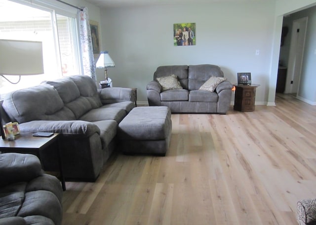 living area with baseboards and wood finished floors