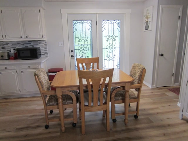 dining area featuring baseboards and light wood-style floors