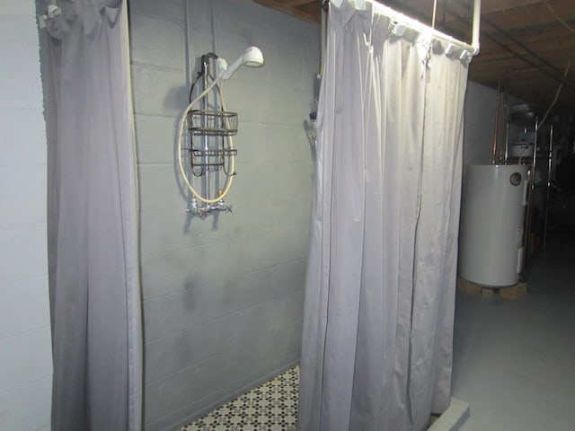 details featuring tiled shower, water heater, and concrete block wall