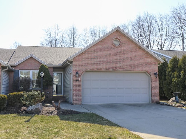 ranch-style house with a front lawn, driveway, an attached garage, a shingled roof, and brick siding