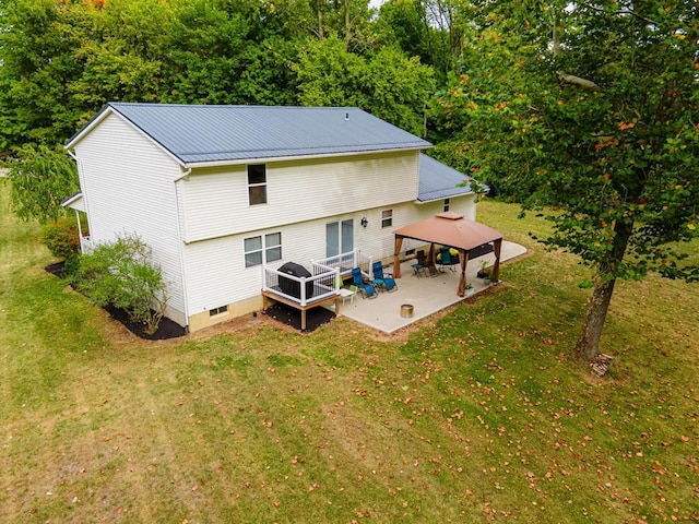 back of property with a gazebo, a patio area, and a lawn