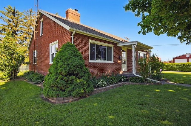 40 Hopewell Ave, Tiffin, OH 44883 - view of front of home with brick siding, a chimney, a front yard, and a shingled roof