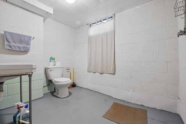 40 Hopewell Ave, Tiffin, OH 44883 - bathroom featuring concrete flooring, toilet, and concrete block wall