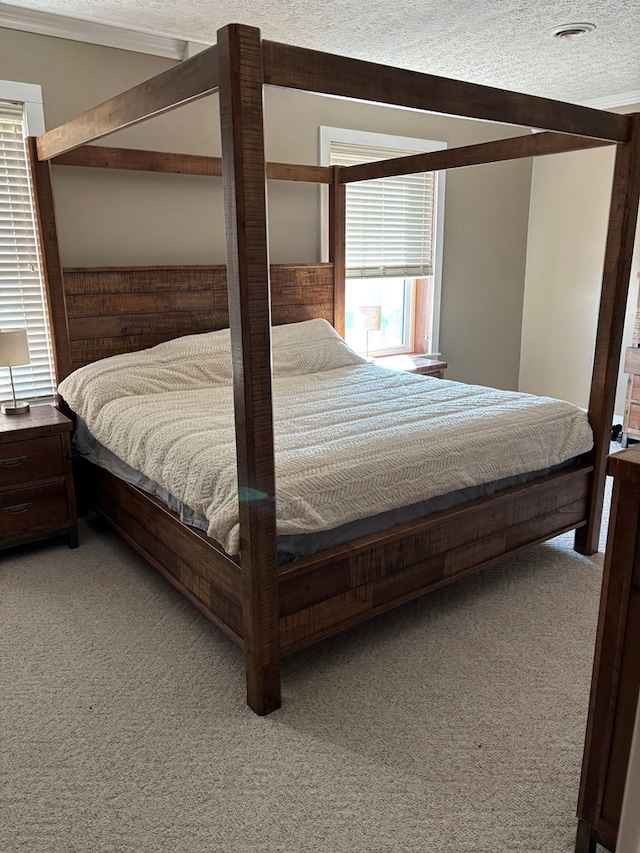 bedroom with light colored carpet and a textured ceiling