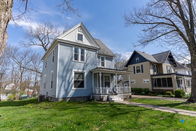 view of front of house featuring cooling unit, covered porch, and a front yard