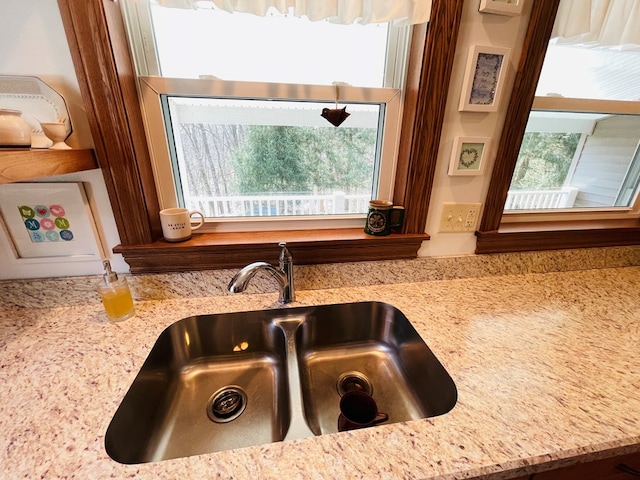 room details featuring light stone countertops and a sink