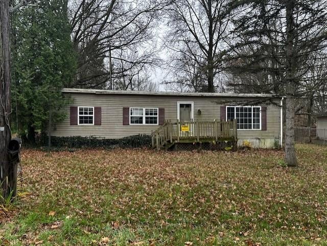 view of front of home with a deck and a front lawn