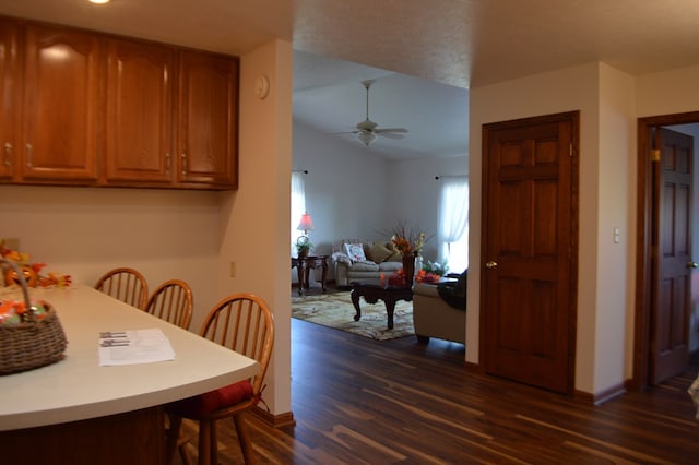 dining area with dark hardwood / wood-style floors, ceiling fan, and lofted ceiling