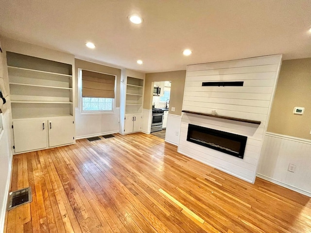 114 Avalon Rd, Mount Vernon, OH 43050 - unfurnished living room featuring light wood finished floors, a large fireplace, recessed lighting, and built in features