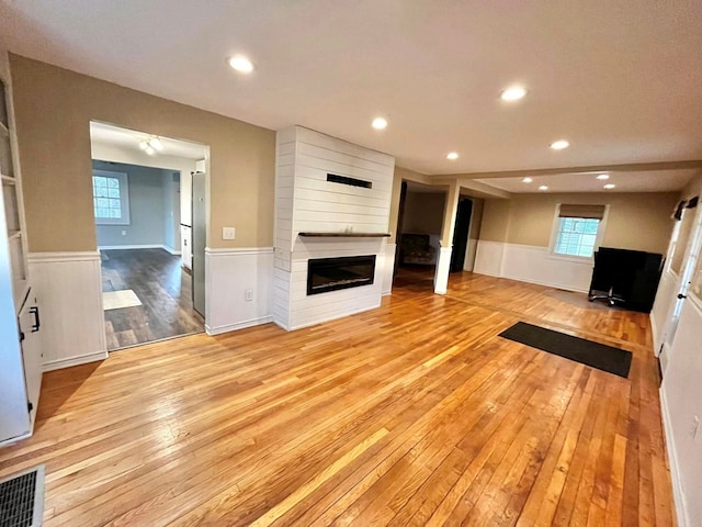 114 Avalon Rd, Mount Vernon, OH 43050 - unfurnished living room featuring wainscoting, hardwood / wood-style floors, a fireplace, recessed lighting, and plenty of natural light