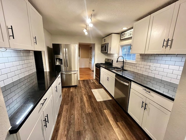 114 Avalon Rd, Mount Vernon, OH 43050 - kitchen with stainless steel appliances, a sink, dark countertops, dark wood finished floors, and a textured ceiling