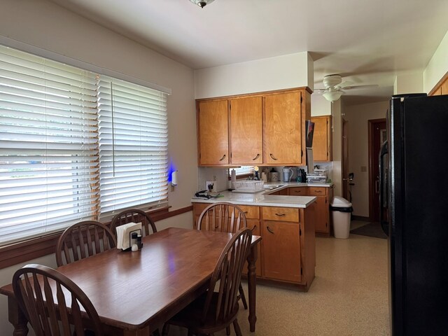 763 Sunnyside Dr, Galion, OH 44833 - kitchen featuring freestanding refrigerator, a peninsula, light countertops, a ceiling fan, and brown cabinets