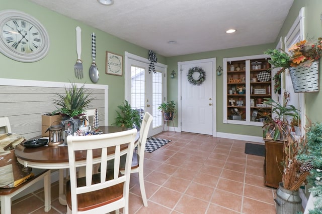 dining space with tile patterned flooring, french doors, and a textured ceiling