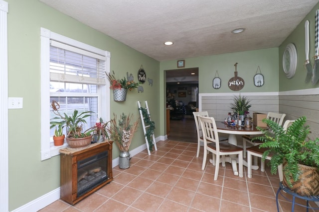 dining area with a textured ceiling and tile patterned floors