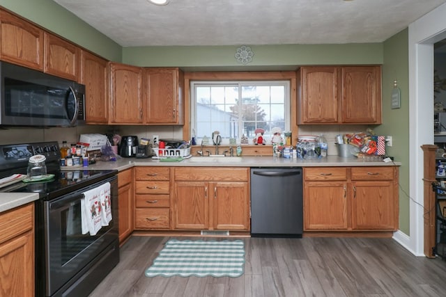 kitchen featuring a textured ceiling, stainless steel appliances, dark wood-type flooring, and sink