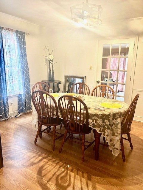dining area with crown molding, light wood finished floors, and a healthy amount of sunlight