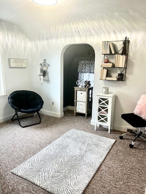 bedroom featuring arched walkways, baseboards, and carpet