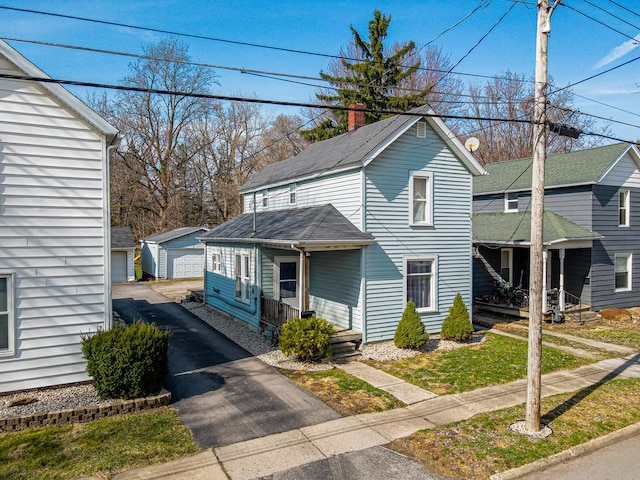 view of front of home featuring a chimney, an outdoor structure, and a porch