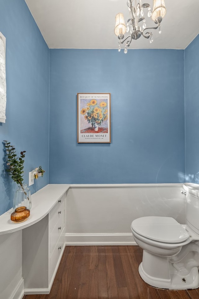 bathroom with hardwood / wood-style flooring, toilet, and a chandelier