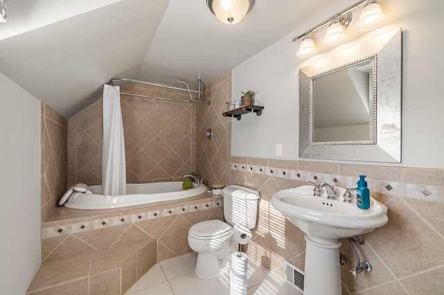 bathroom featuring shower / tub combo with curtain, lofted ceiling, toilet, tile walls, and tile patterned flooring